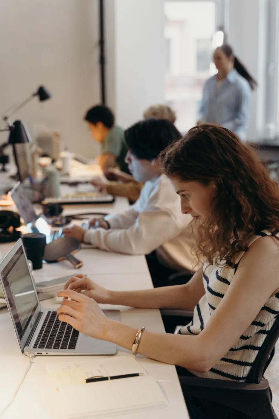 Personas trabajando con sus computadoras en una oficina compartida